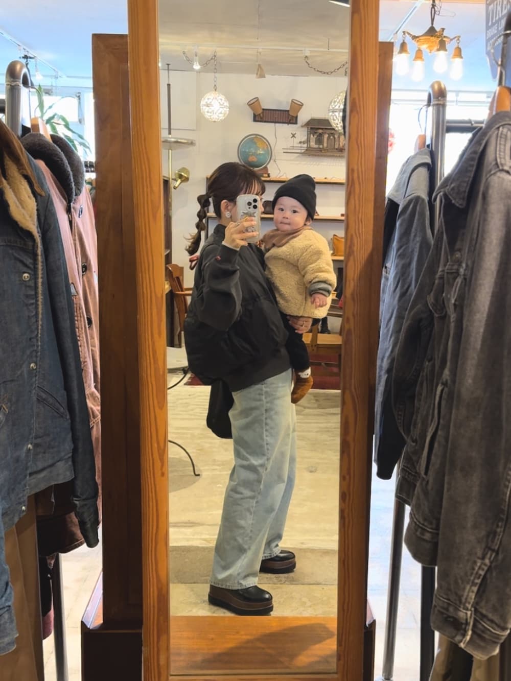 ブラック系のダウンベスト、グレー系のスウェット、ブルー系のデニムパンツを着用したレディースの冬コーディネートの2枚目の写真