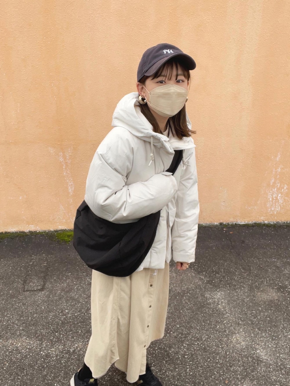 ホワイト系のワンピース、ホワイト系のジャケット/アウター、ブラック系のショルダーバッグを着用したレディースの冬コーディネートの3枚目の写真