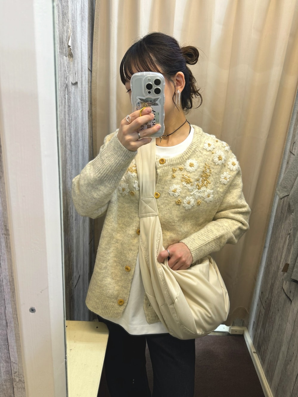 ベージュ系のニット/セーター、ホワイト系のショルダーバッグ、ブラック系のデニムパンツを着用したレディースの秋コーディネートの5枚目の写真