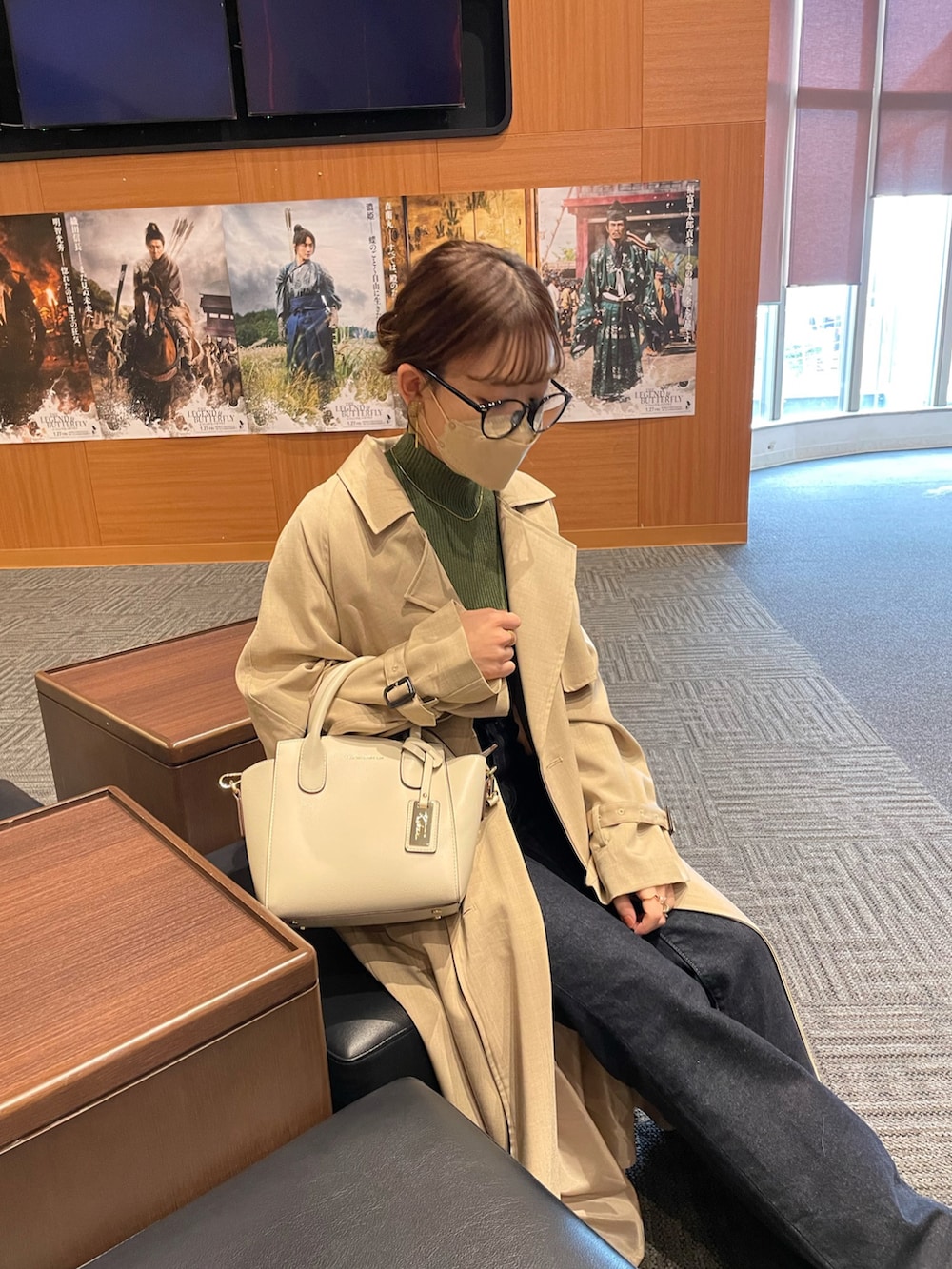 ホワイト系のハンドバッグ、グリーン系のニット/セーター、ベージュ系のトレンチコートを着用したレディースの冬コーディネートの3枚目の写真