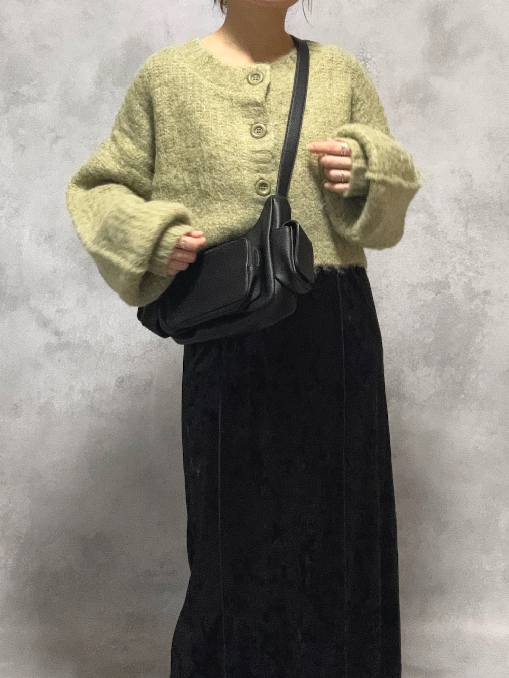 グリーン系のカーディガン/ボレロ、ブラック系のワンピース、ブラック系のショルダーバッグを着用したレディースの秋コーディネートの3枚目の写真