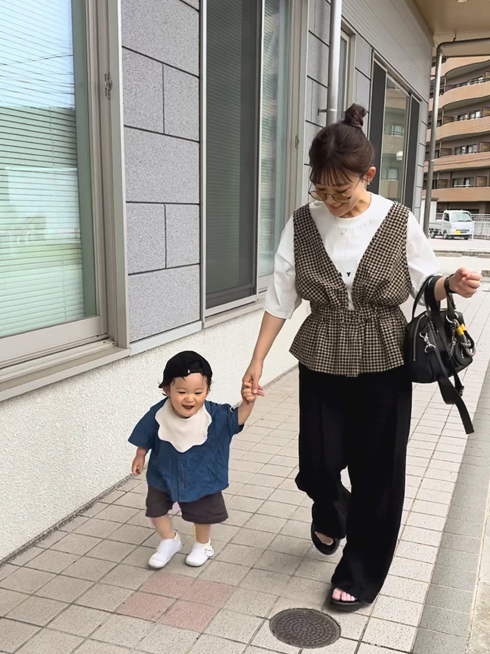 ブラック系のスウェットパンツ、ブラウン系のベスト、ホワイト系のTシャツ/カットソーを着用したレディースの夏コーディネートの4枚目の写真