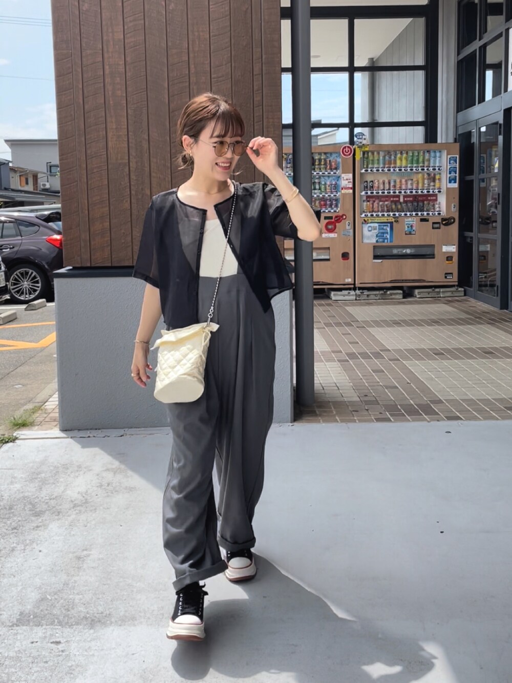 ブラック系のスニーカー、ブラック系のシャツ/ブラウス、ホワイト系のキャミソールを着用したレディースの夏コーディネートの4枚目の写真