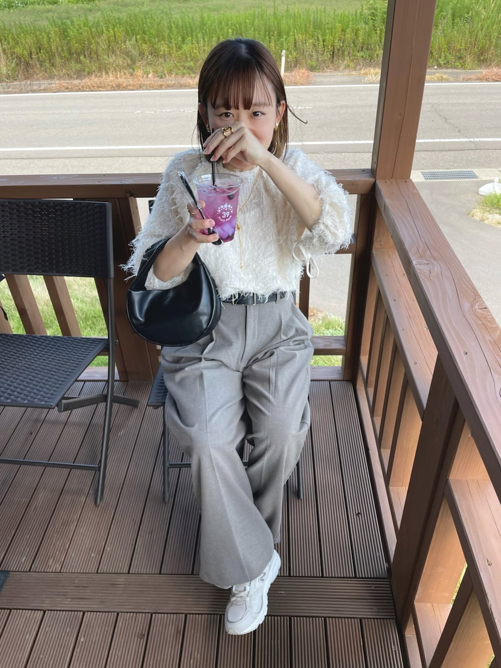 ホワイト系のシャツ/ブラウス、ブラウン系のパンツ、ブラック系のハンドバッグを着用したレディースの夏コーディネートの5枚目の写真