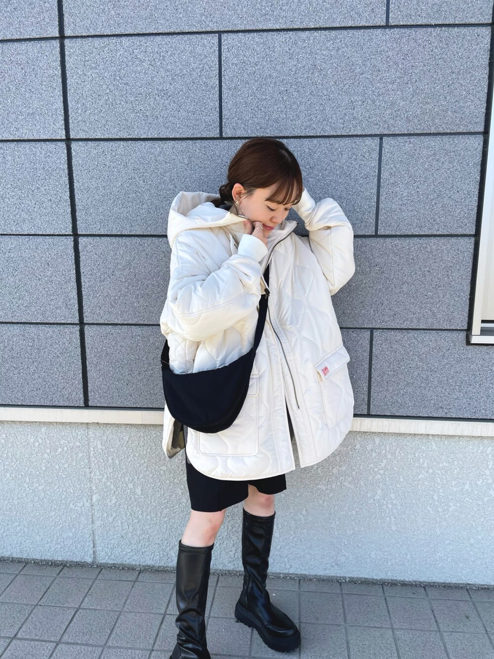 ホワイト系のブルゾン、グレー系のニット/セーター、ブラック系のショルダーバッグを着用したレディースの冬コーディネートの4枚目の写真