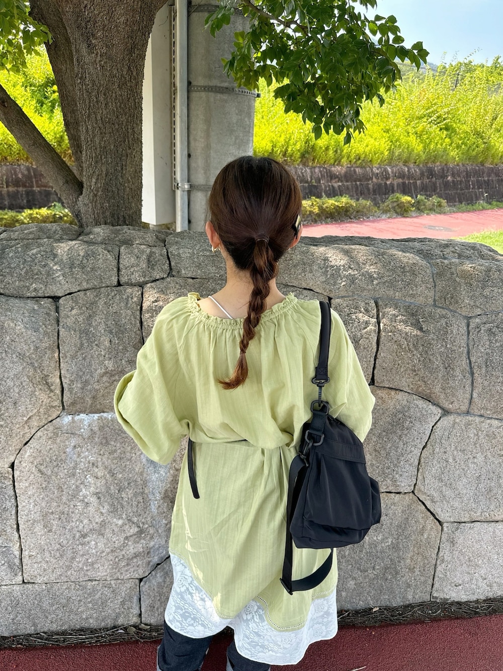 グリーン系のワンピース、ホワイト系のスニーカー、ブルー系のデニムパンツを着用したレディースの夏コーディネートの4枚目の写真