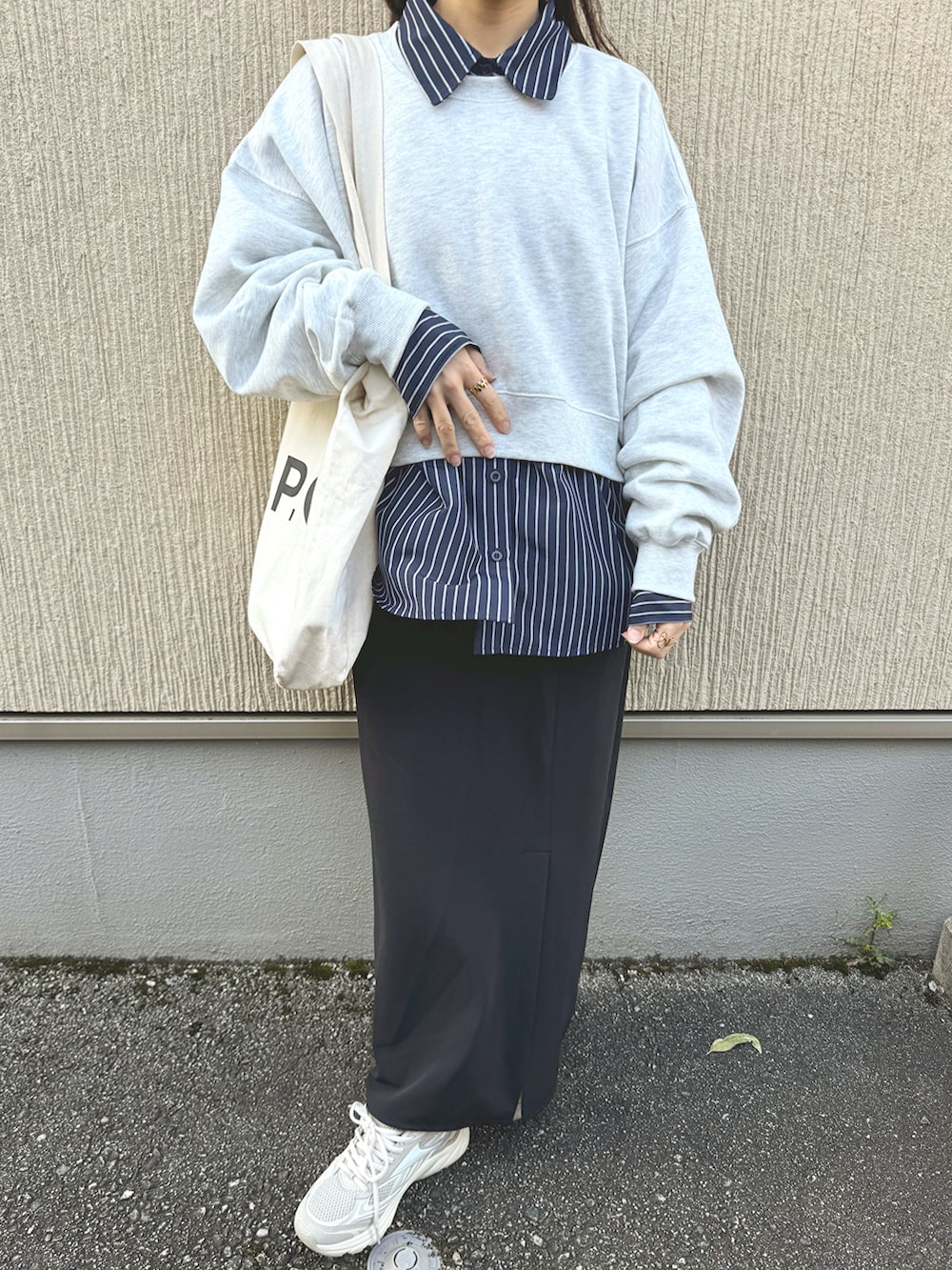 ブルー系のシャツ/ブラウス、ブラック系のスカート、ベージュ系のスニーカーを着用したレディースの春コーディネートの3枚目の写真