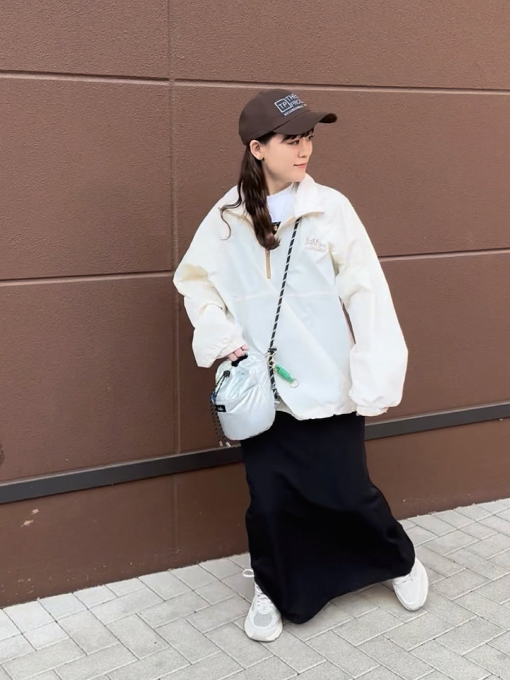 ホワイト系のブルゾン、ブラック系のワンピース、ベージュ系のスニーカーを着用したレディースの春コーディネートの3枚目の写真