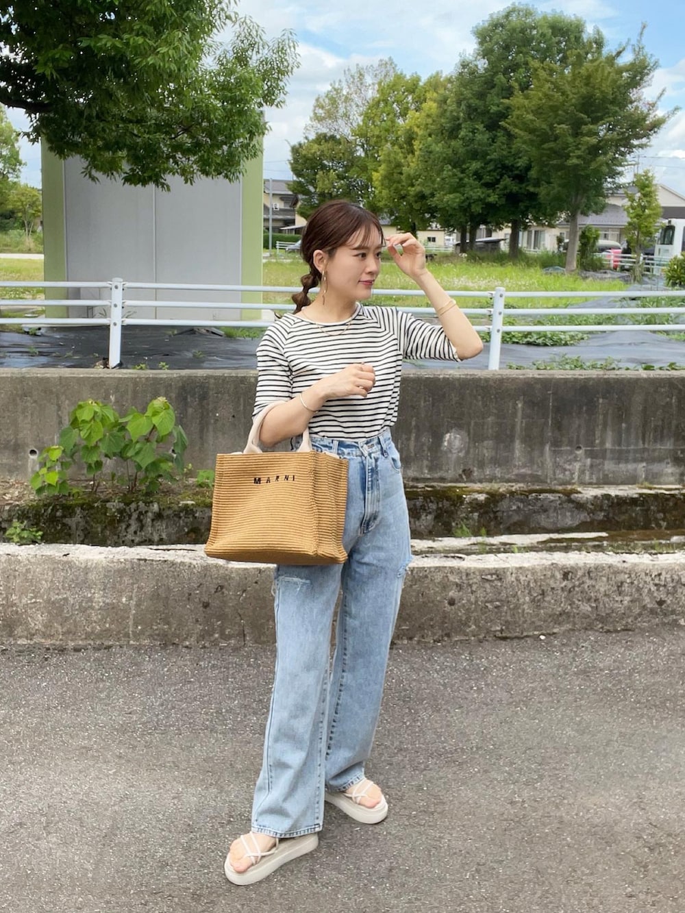 ブルー系のTシャツ/カットソー、その他のデニムパンツ、ベージュ系のショルダーバッグを着用したレディースの夏コーディネートの2枚目の写真