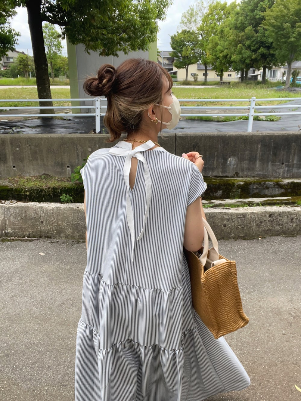 ブラック系のワンピース、ベージュ系のショルダーバッグ、ブラック系のサンダルを着用したレディースの夏コーディネートの4枚目の写真