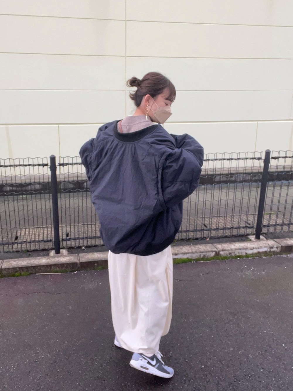 ホワイト系のシャツワンピース、ブラウン系のベスト、ブラック系のMA-1を着用したレディースの秋コーディネートの4枚目の写真