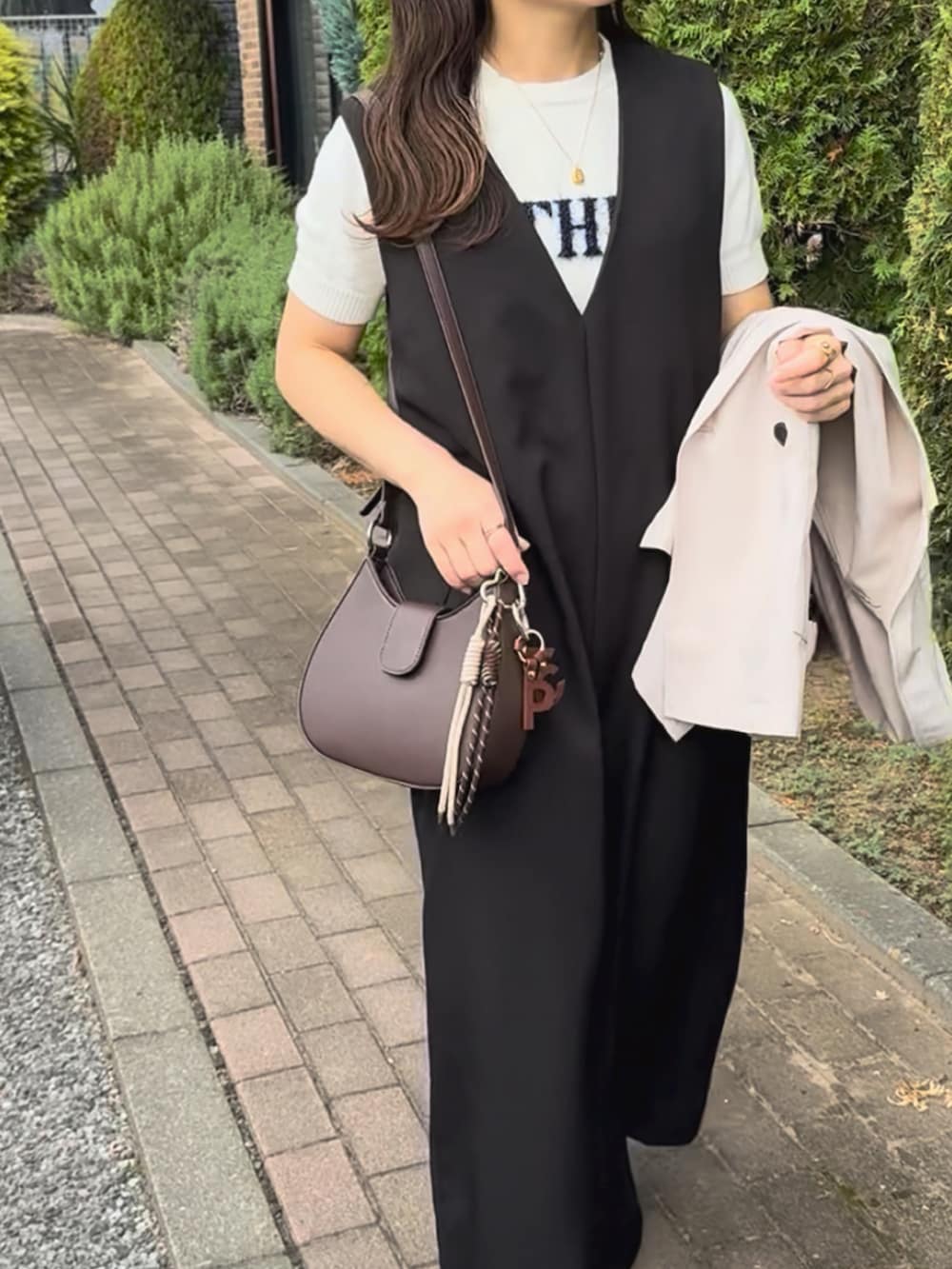 ベージュ系のテーラードジャケット、ブラック系のワンピース、ホワイト系のニット/セーターを着用したレディースの秋コーディネートの3枚目の写真