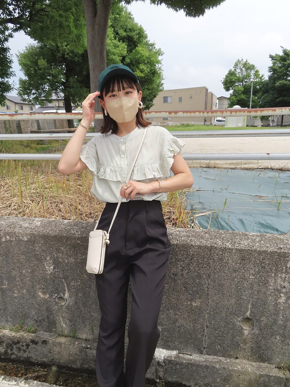 グリーン系のシャツ/ブラウス、ブラック系のスラックス、ブラック系のサンダルを着用したレディースの夏コーディネートの4枚目の写真