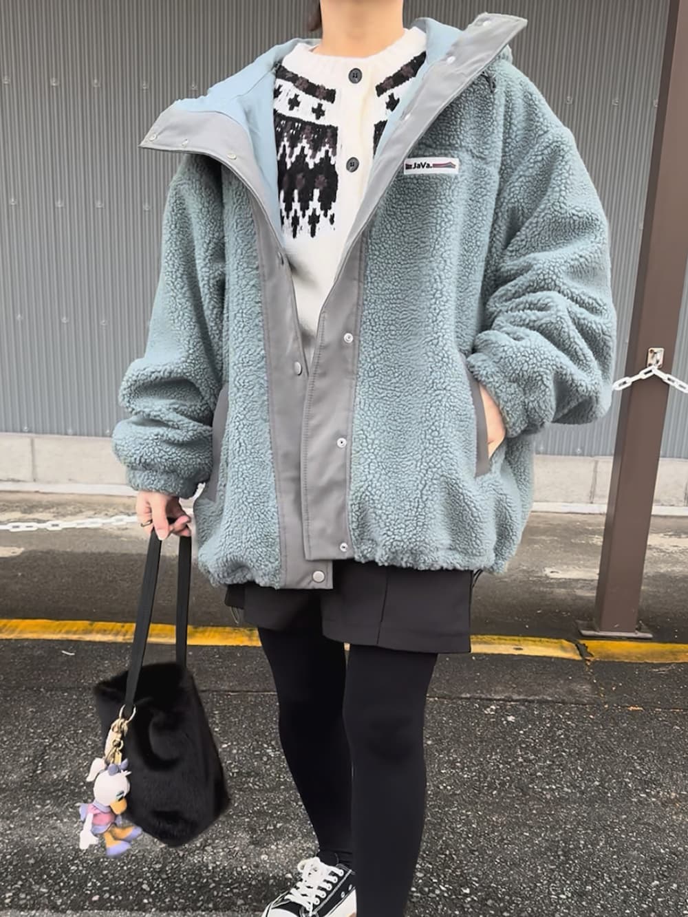 ブルー系のブルゾン、ブラック系のスラックス、ホワイト系のカーディガン/ボレロを着用したレディースの冬コーディネートの4枚目の写真