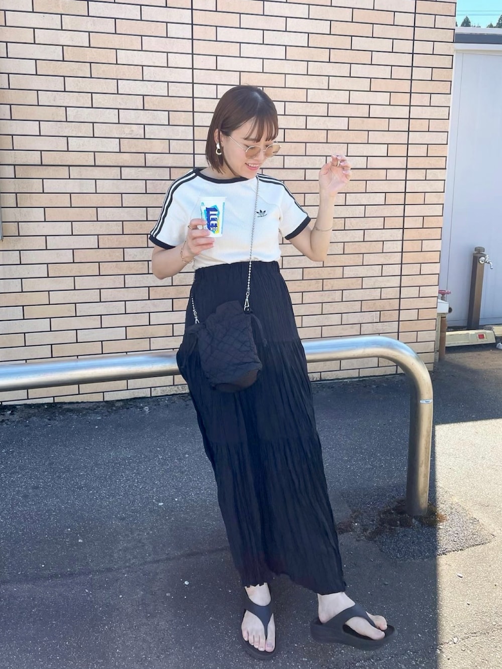 ホワイト系のTシャツ/カットソー、ブラック系のスカート、ブラック系のショルダーバッグを着用したレディースの夏コーディネートの2枚目の写真