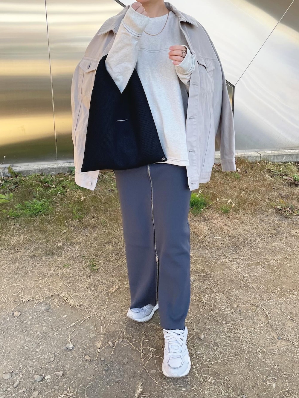 グレー系のデニムジャケット、ベージュ系のTシャツ/カットソー、グレー系のスカートを着用したレディースの春コーディネートの2枚目の写真