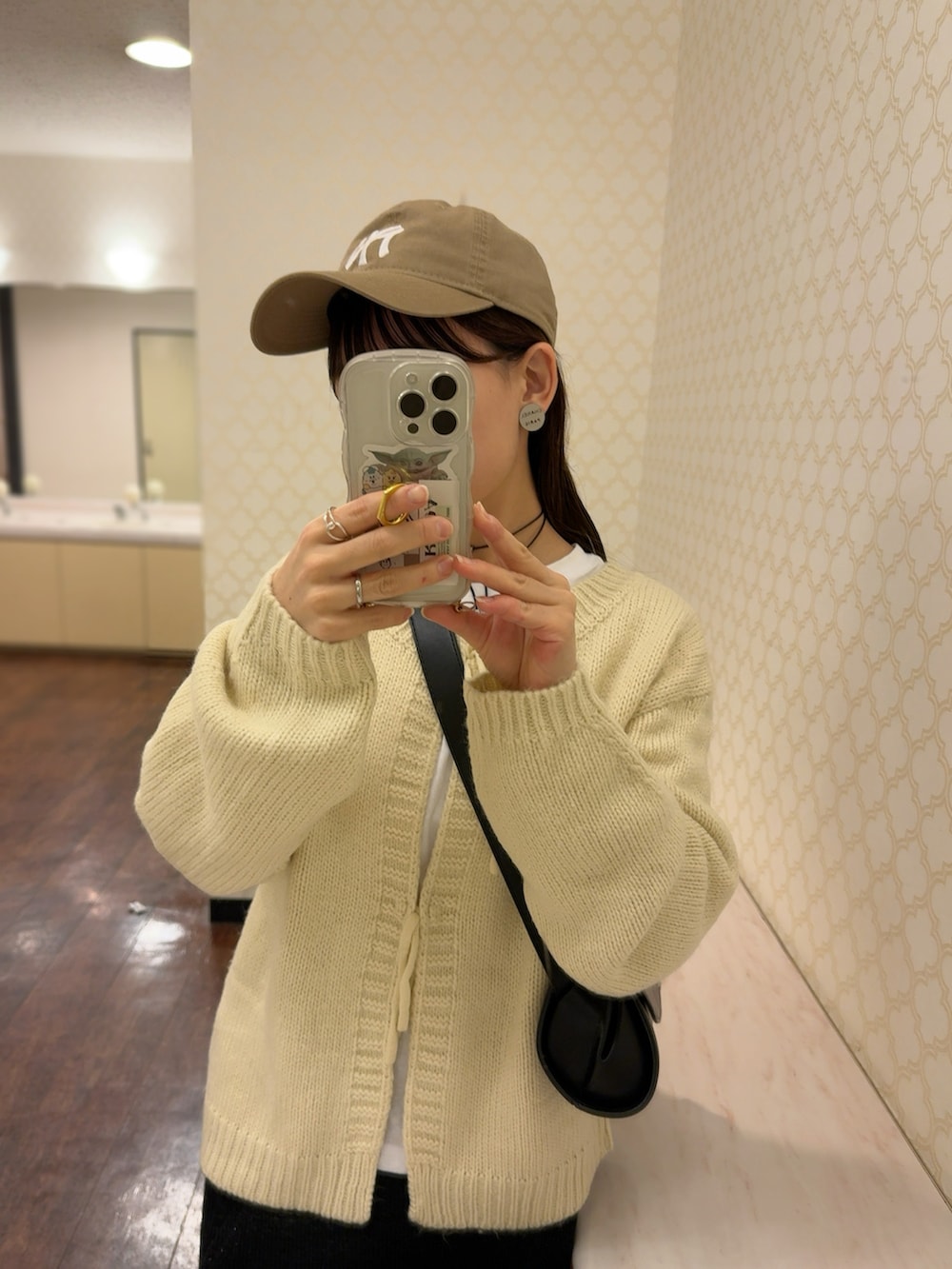 ホワイト系のカーディガン/ボレロ、ブラック系のスカート、ブラック系のショルダーバッグを着用したレディースの冬コーディネートの4枚目の写真