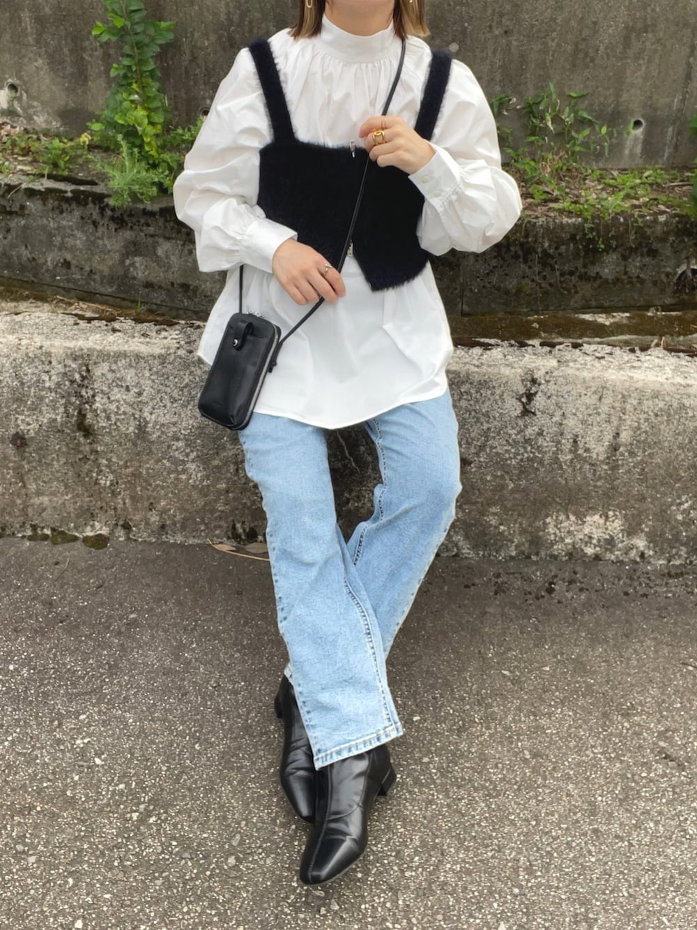 ホワイト系のシャツ/ブラウス、ブラック系のベスト、ブルー系のデニムパンツを着用したレディースの秋コーディネートの3枚目の写真