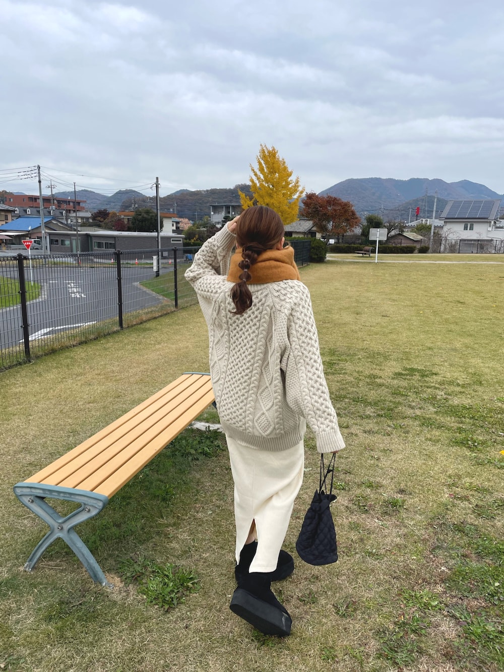 ホワイト系のニット/セーター、ホワイト系のスカート、ブラック系のブーツを着用したレディースの冬コーディネートの4枚目の写真