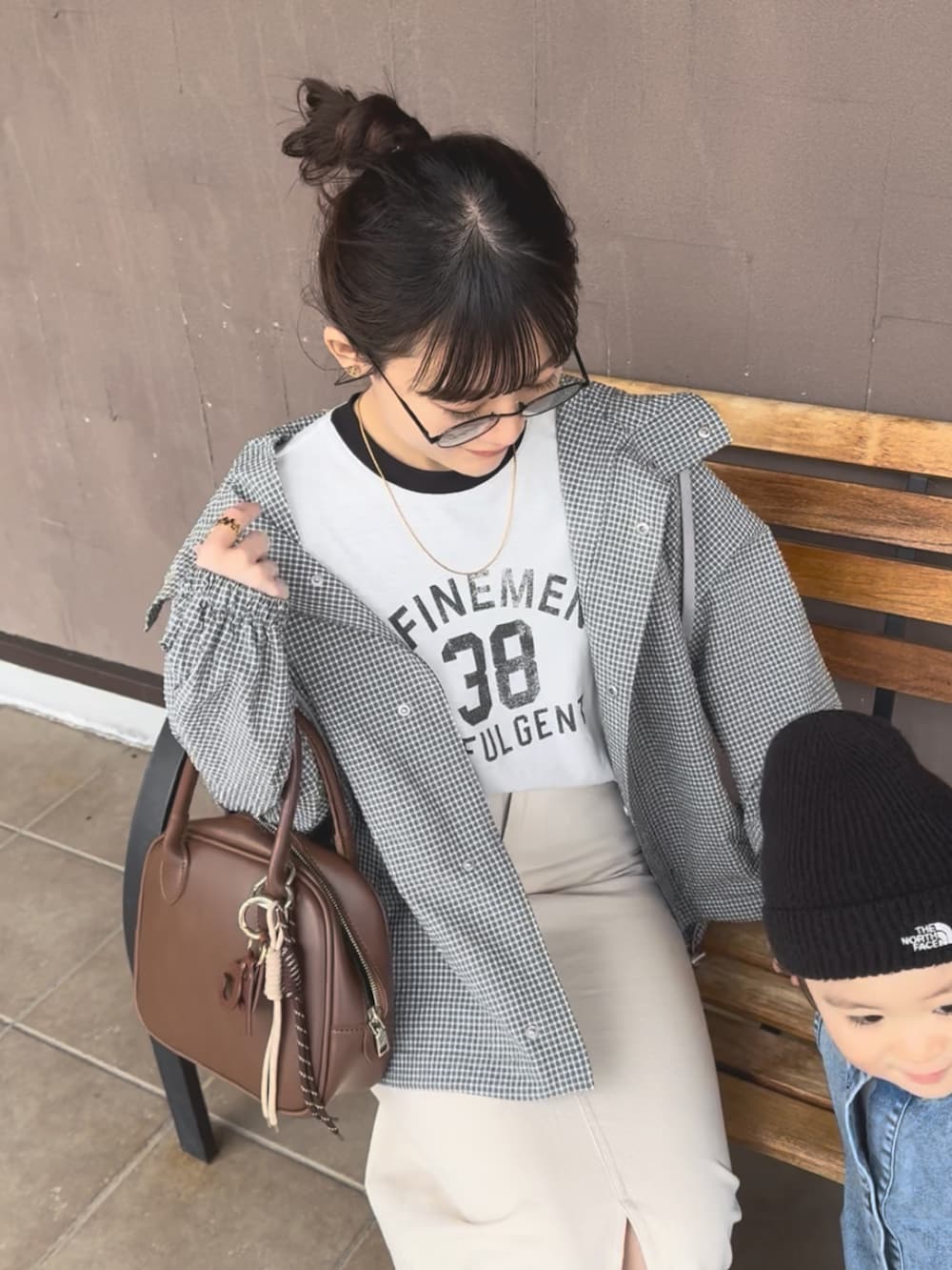グレー系のブルゾン、ブラウン系のショルダーバッグ、ホワイト系のTシャツ/カットソーを着用したレディースの春コーディネートの2枚目の写真