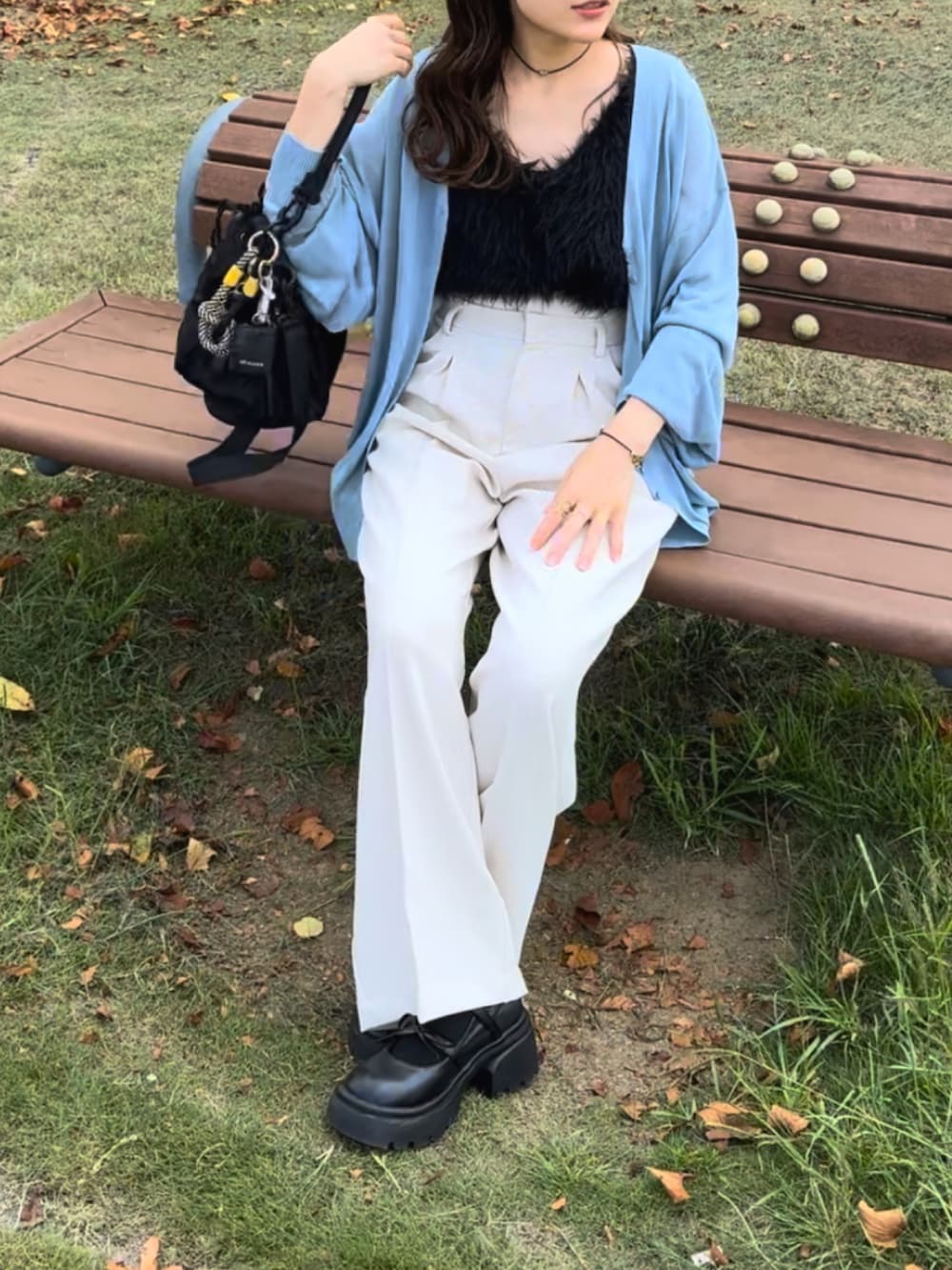 ブルー系のカーディガン/ボレロ、ホワイト系のスラックス、ブラック系のベストを着用したレディースの秋コーディネートの3枚目の写真