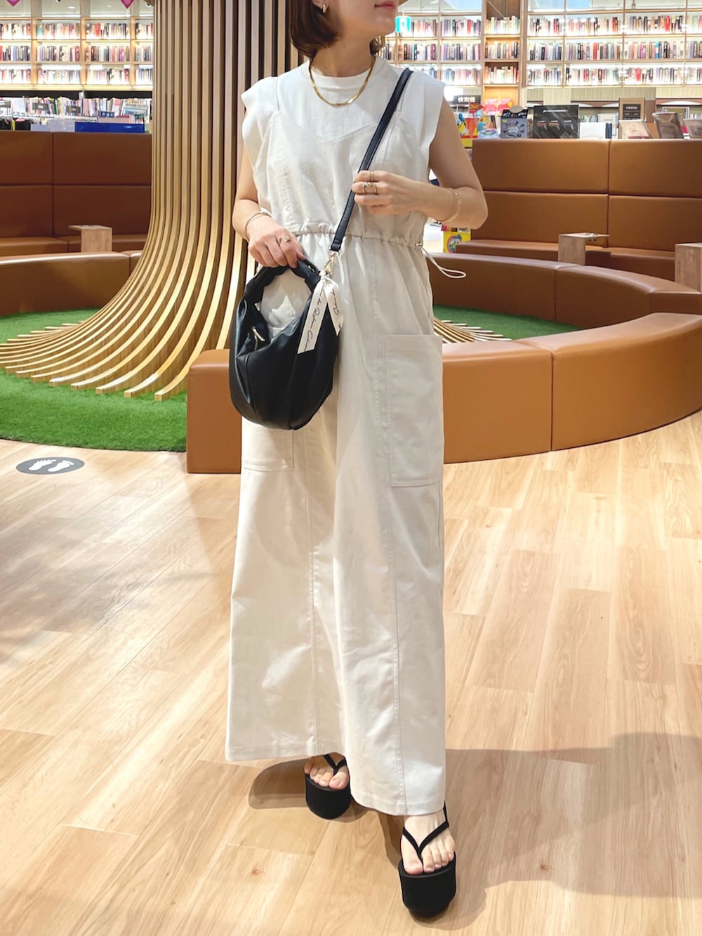 ベージュ系のワンピース/ドレス、ホワイト系のニット/セーター、ブラック系のハンドバッグを着用したレディースの夏コーディネートの4枚目の写真