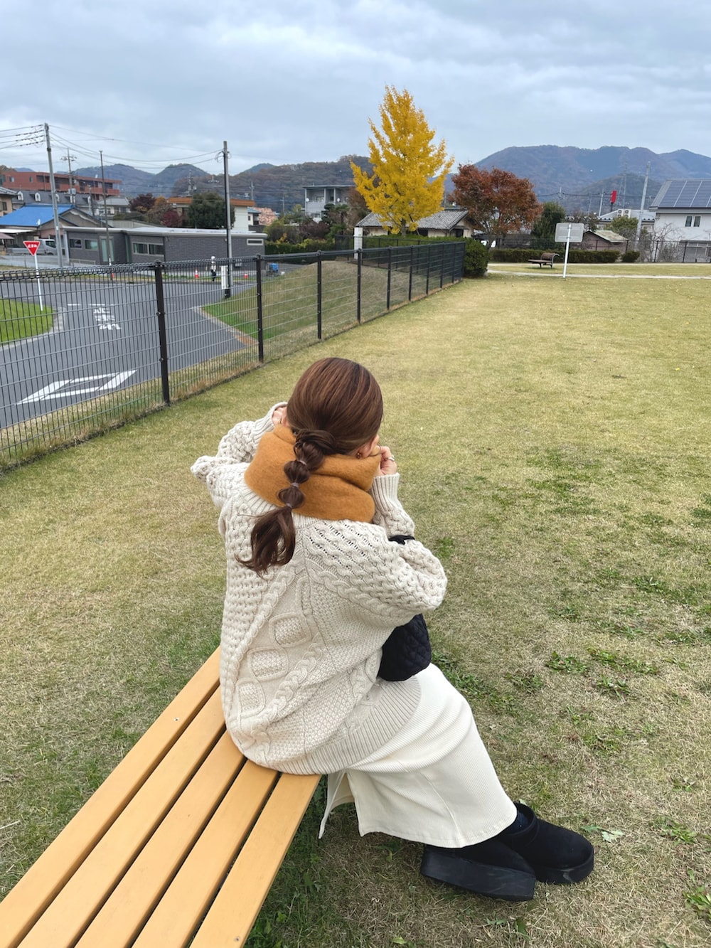 ホワイト系のニット/セーター、ホワイト系のスカート、ブラック系のブーツを着用したレディースの冬コーディネートの2枚目の写真