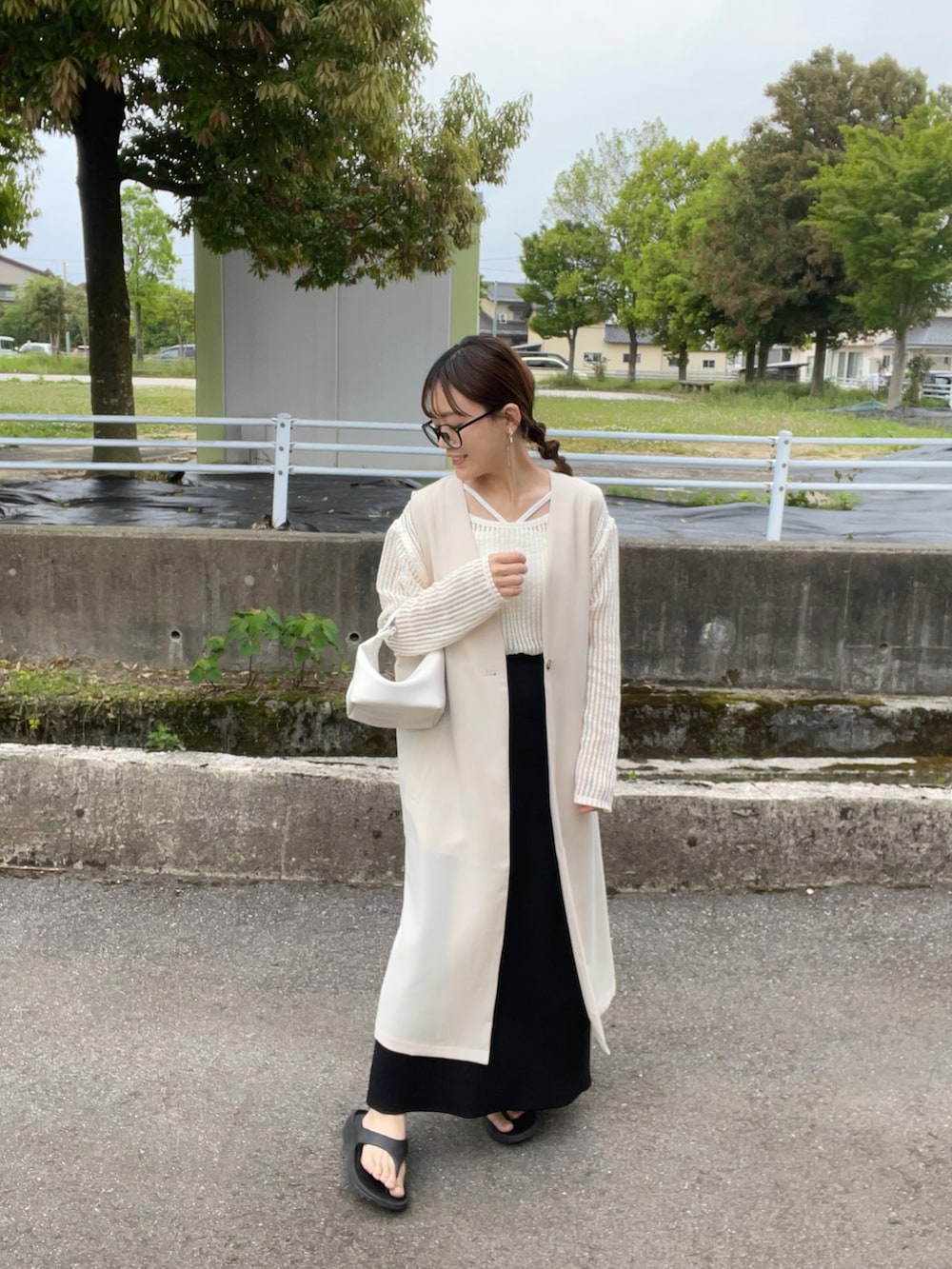 ホワイト系のベスト、ベージュ系のTシャツ/カットソー、ホワイト系のキャミソールを着用したレディースの春コーディネートの2枚目の写真