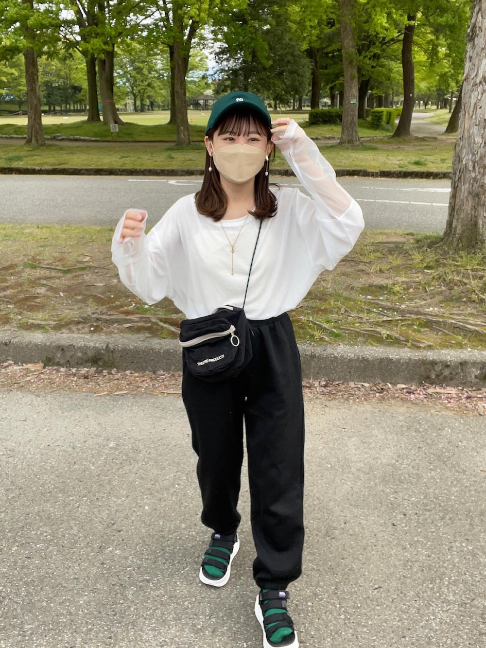 ホワイト系のTシャツ/カットソー、ブラック系のスウェットパンツ、ブラック系のショルダーバッグを着用したレディースの春コーディネートの4枚目の写真