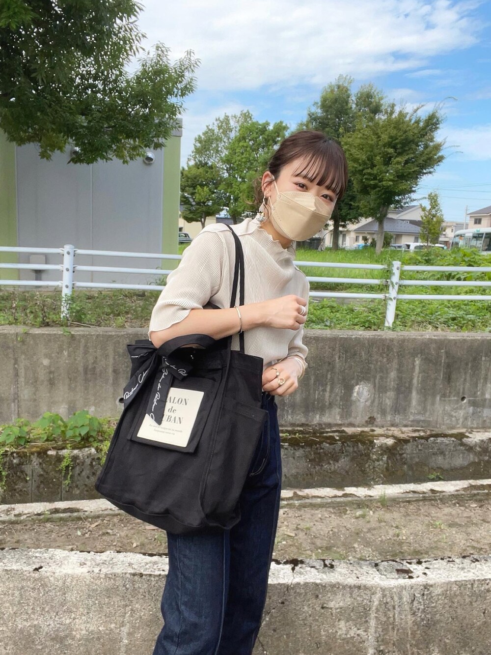 ホワイト系のTシャツ/カットソー、グレー系のベスト、ブラック系のトートバッグを着用したレディースの夏コーディネートの4枚目の写真