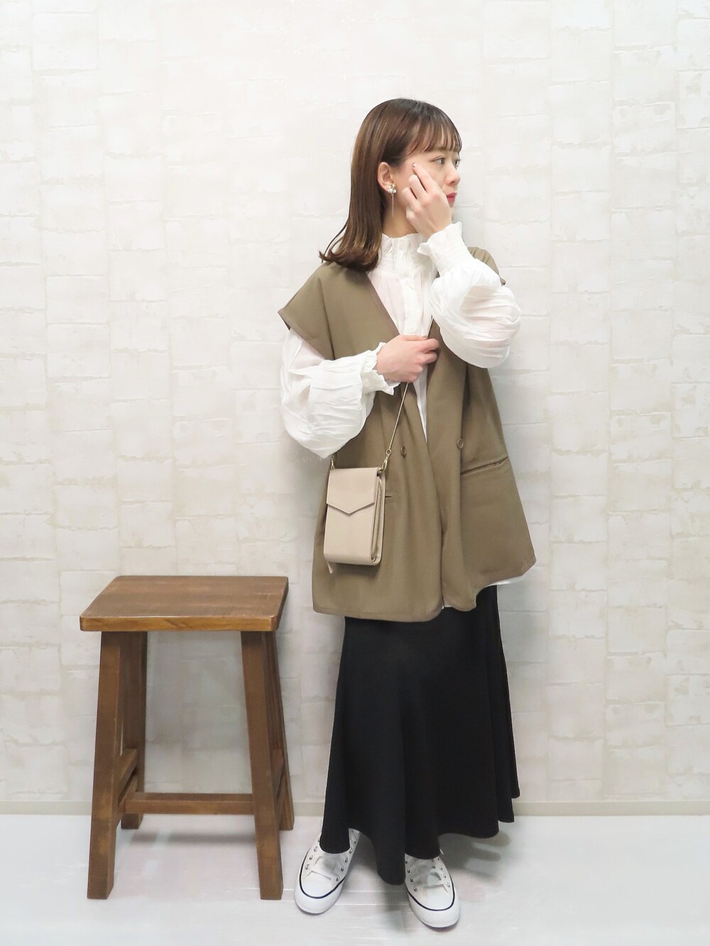 ホワイト系のシャツ/ブラウス、ブラウン系のベスト、ブラック系のスカートを着用したレディースの春コーディネートの2枚目の写真