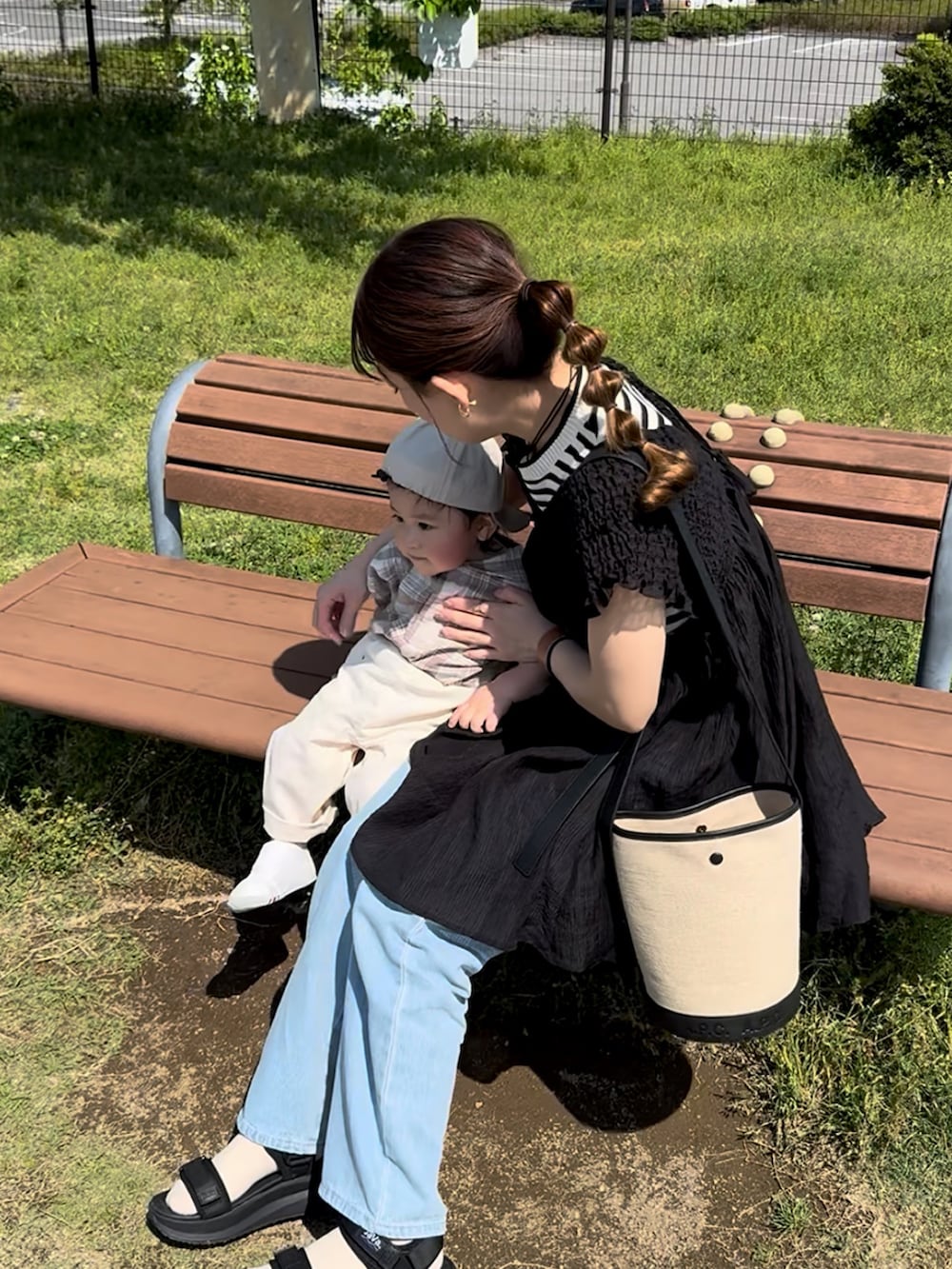 ブラック系のトップス、ホワイト系のタンクトップ、ブラック系のショルダーバッグを着用したレディースの夏コーディネートの3枚目の写真