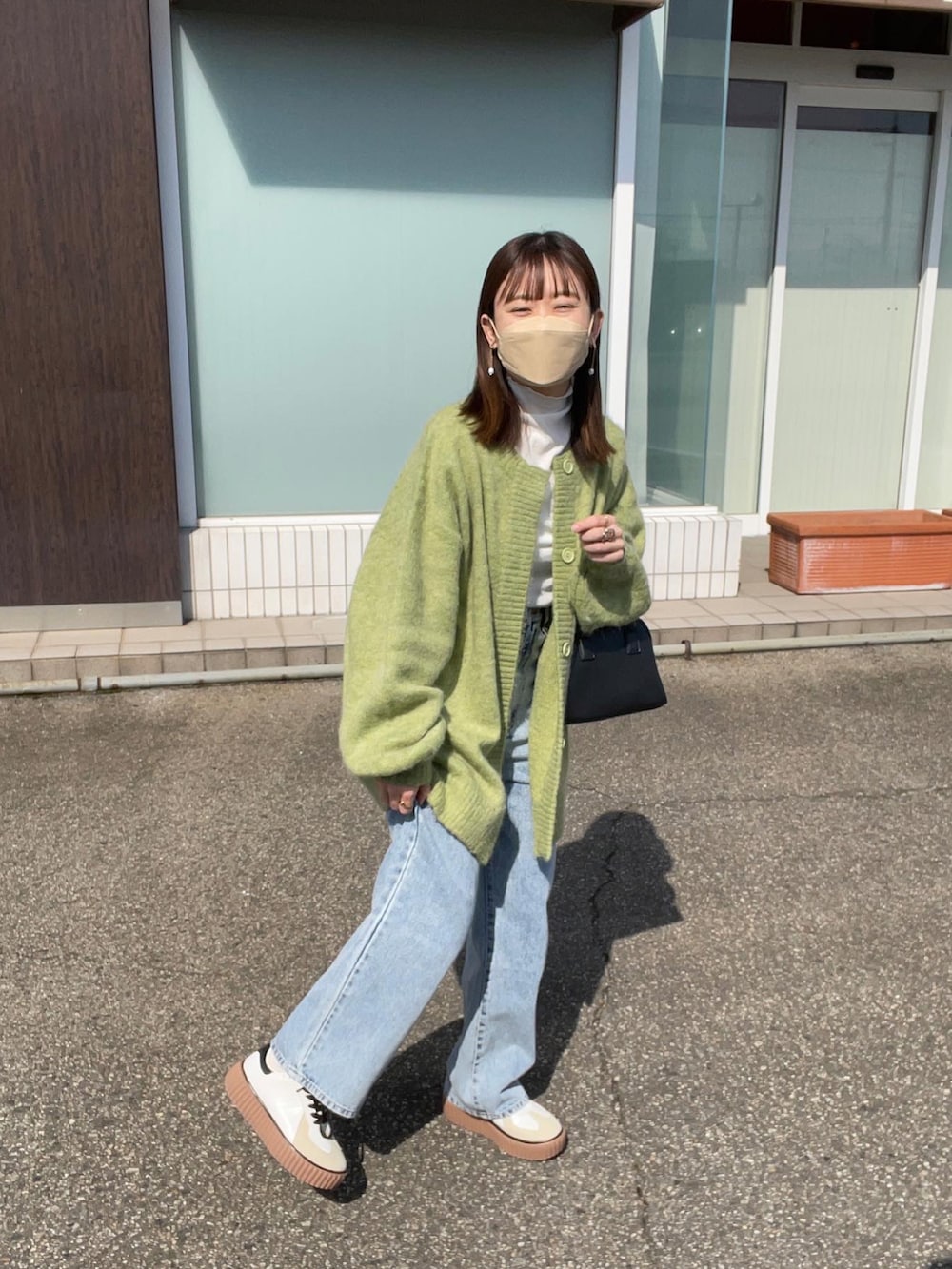 グリーン系のカーディガン/ボレロ、ホワイト系のTシャツ/カットソー、その他のデニムパンツを着用したレディースの春コーディネートの4枚目の写真