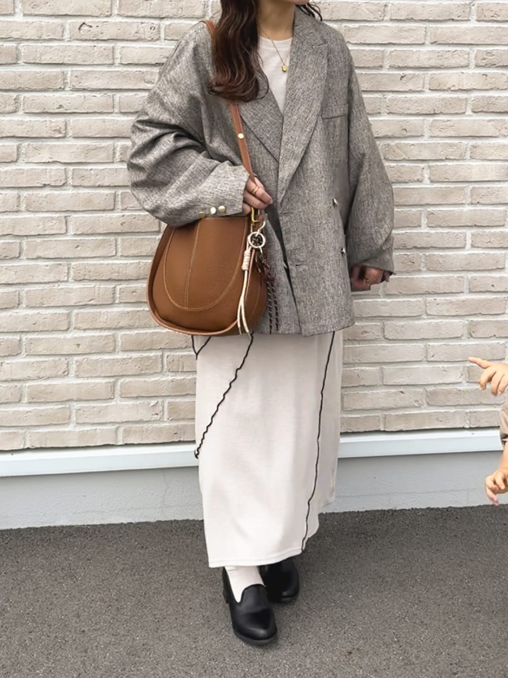 ベージュ系のテーラードジャケット、ベージュ系のワンピース、ブラウン系のショルダーバッグを着用したレディースの秋コーディネートの5枚目の写真