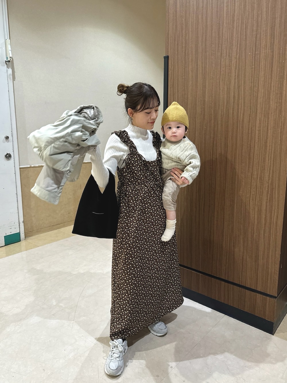 ブラウン系のワンピース/ドレス、ベージュ系のダウンベスト、ホワイト系のニット/セーターを着用したレディースの冬コーディネートの2枚目の写真