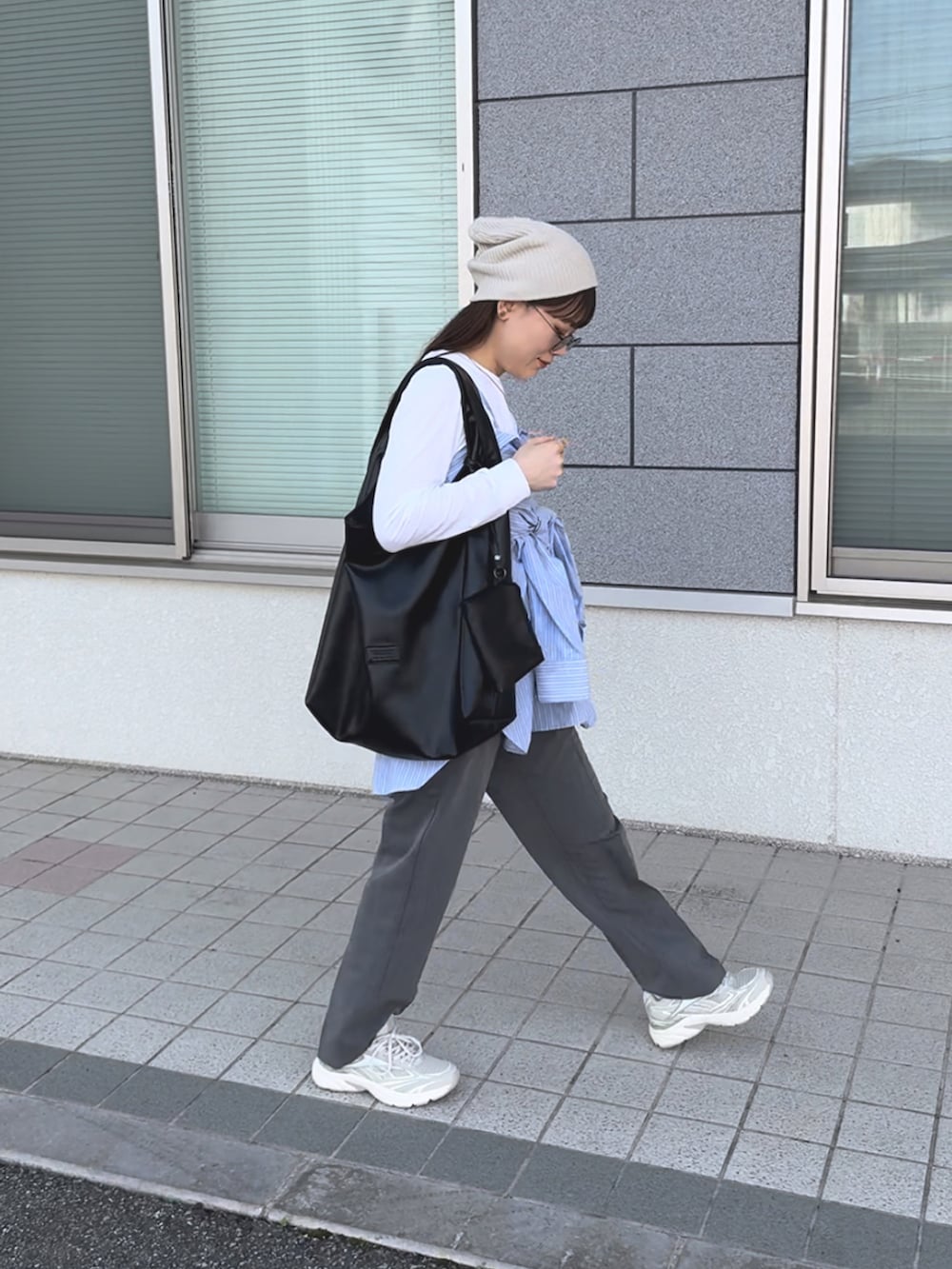 ベージュ系のスニーカー、ブルー系のシャツ/ブラウス、グレー系のパンツを着用したレディースの春コーディネートの4枚目の写真