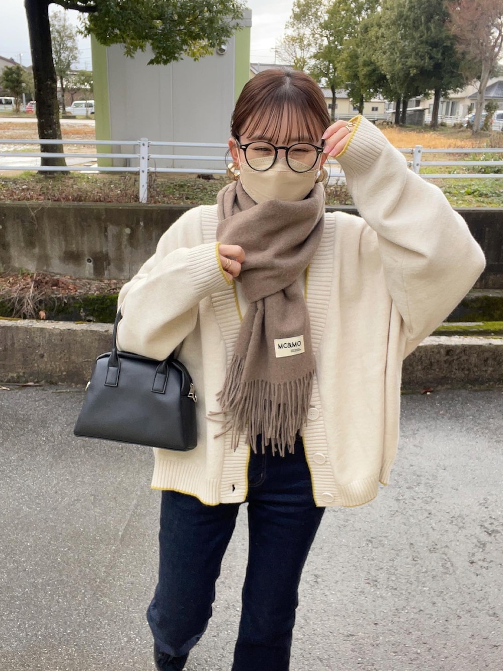 ホワイト系のカーディガン/ボレロ、ホワイト系のニット/セーター、ブルー系のデニムパンツを着用したレディースの冬コーディネートの4枚目の写真