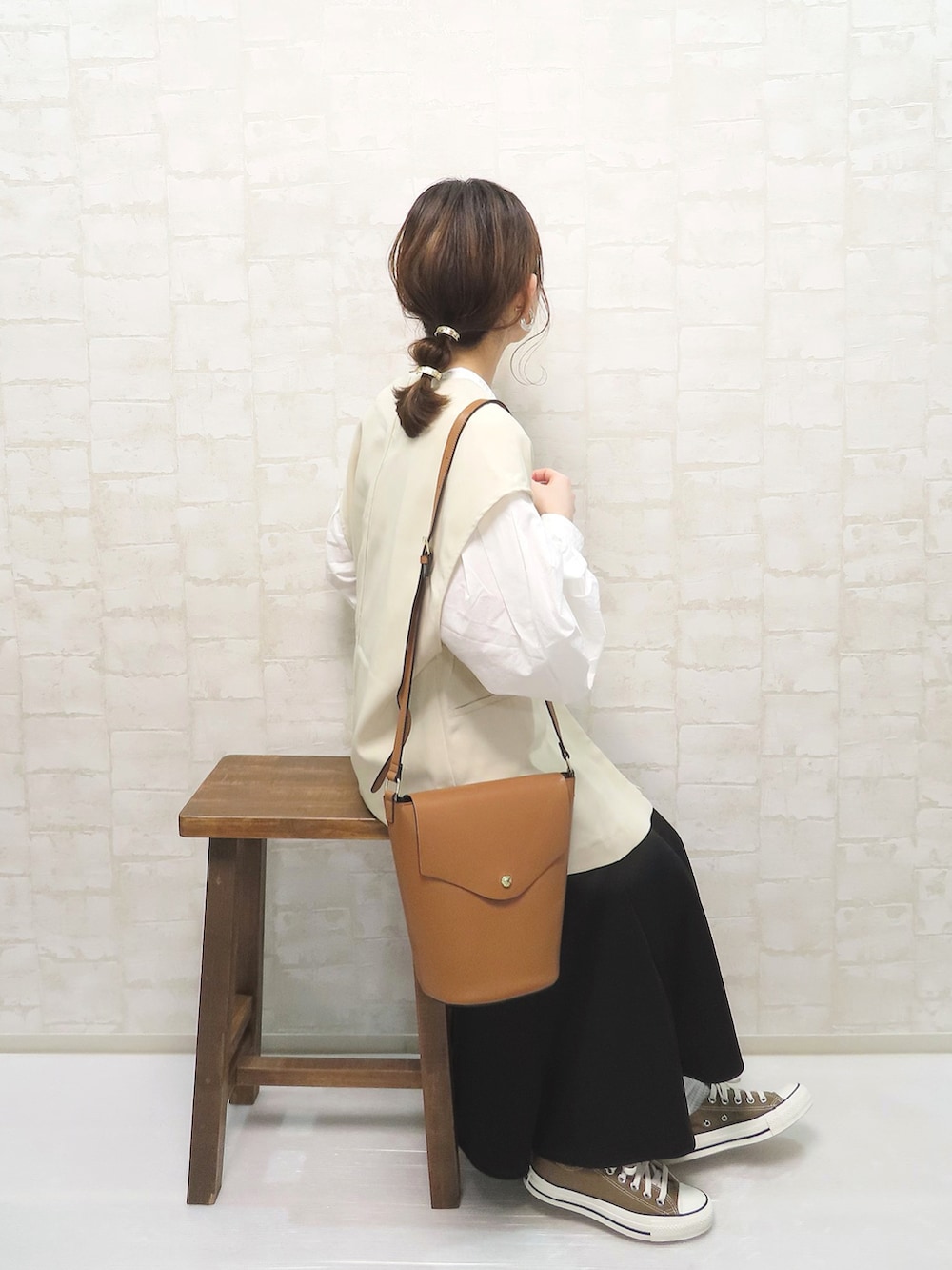 ホワイト系のシャツ/ブラウス、ホワイト系のベスト、ブラック系のスカートを着用したレディースの春コーディネートの2枚目の写真