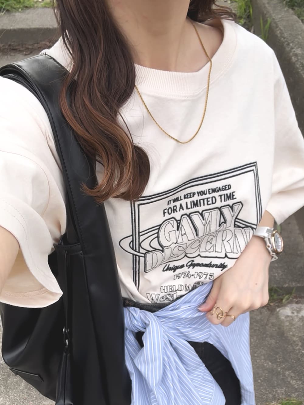 ホワイト系のTシャツ/カットソー、ベージュ系のスニーカー、ブラック系のデニムスカートを着用したレディースの夏コーディネートの4枚目の写真