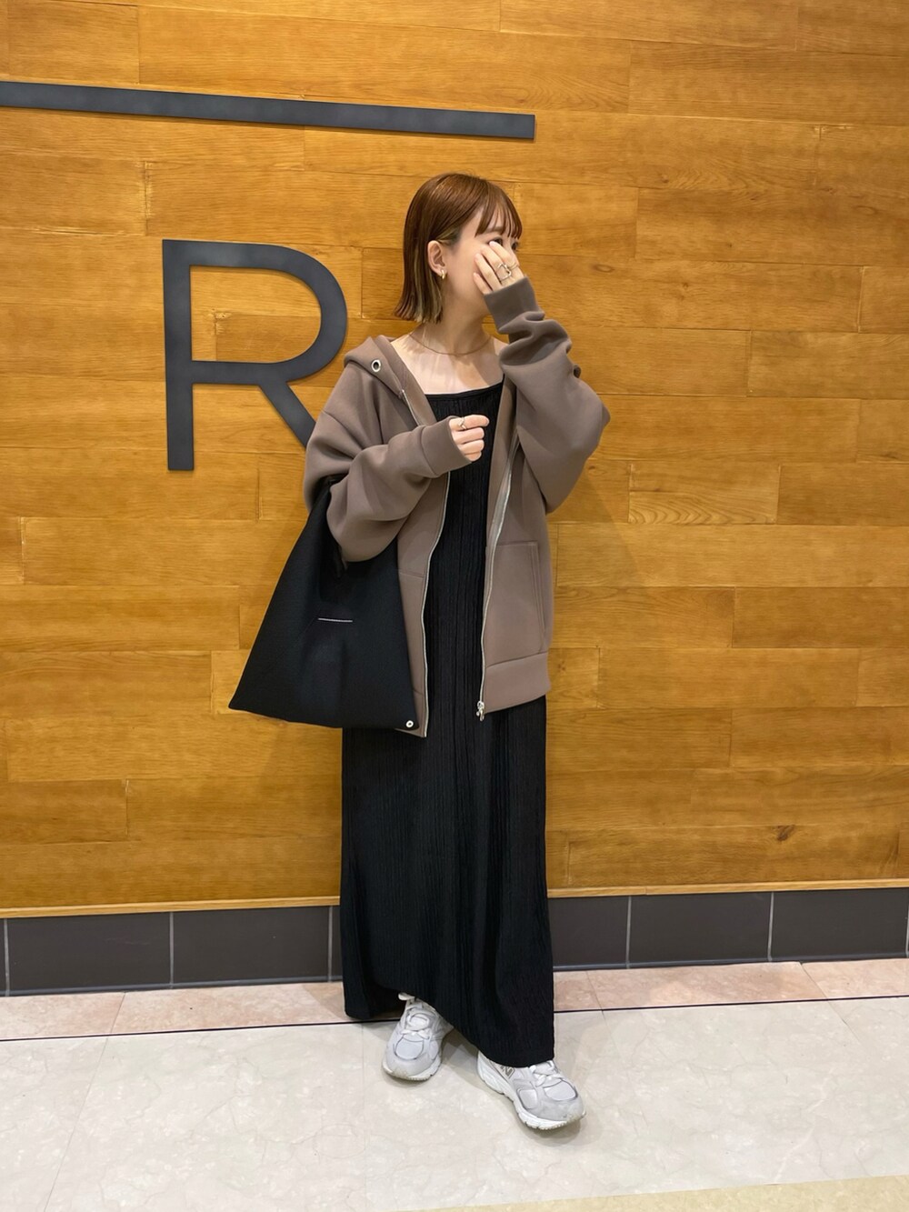 ブラウン系のパーカー、ブラック系のワンピース/ドレス、ブラック系のトートバッグを着用したレディースの秋コーディネートの4枚目の写真