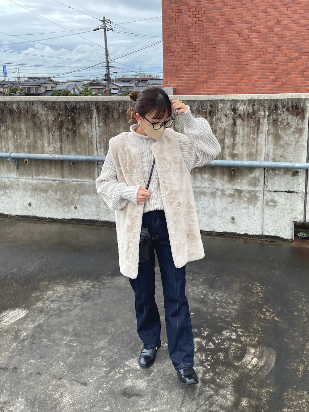 ベージュ系のニット/セーター、グレー系のベスト、ブラック系のデニムパンツを着用したレディースの秋コーディネートの5枚目の写真