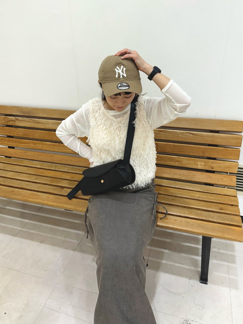 グレー系のスカート、ホワイト系のトップス、ホワイト系のTシャツ/カットソーを着用したレディースの秋コーディネートの3枚目の写真