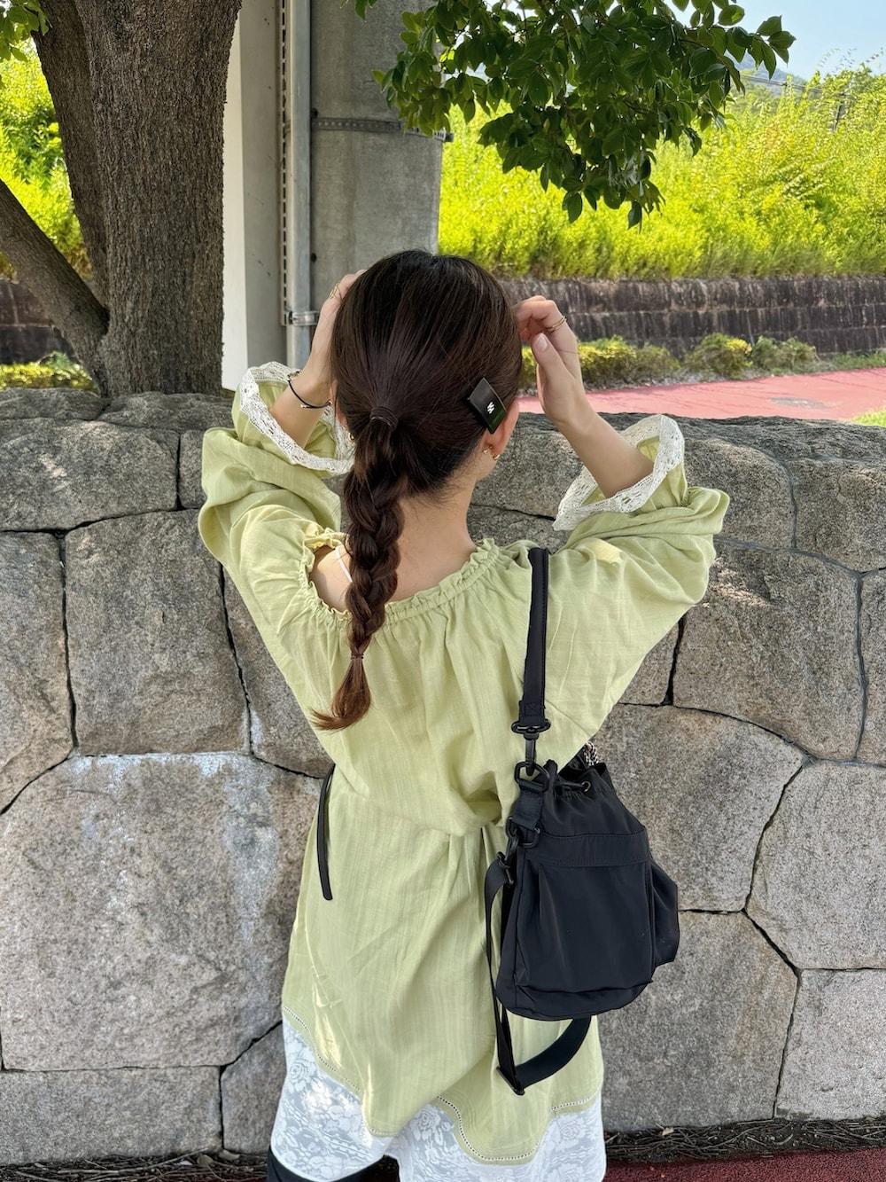 グリーン系のワンピース、ホワイト系のスニーカー、ブルー系のデニムパンツを着用したレディースの夏コーディネートの2枚目の写真