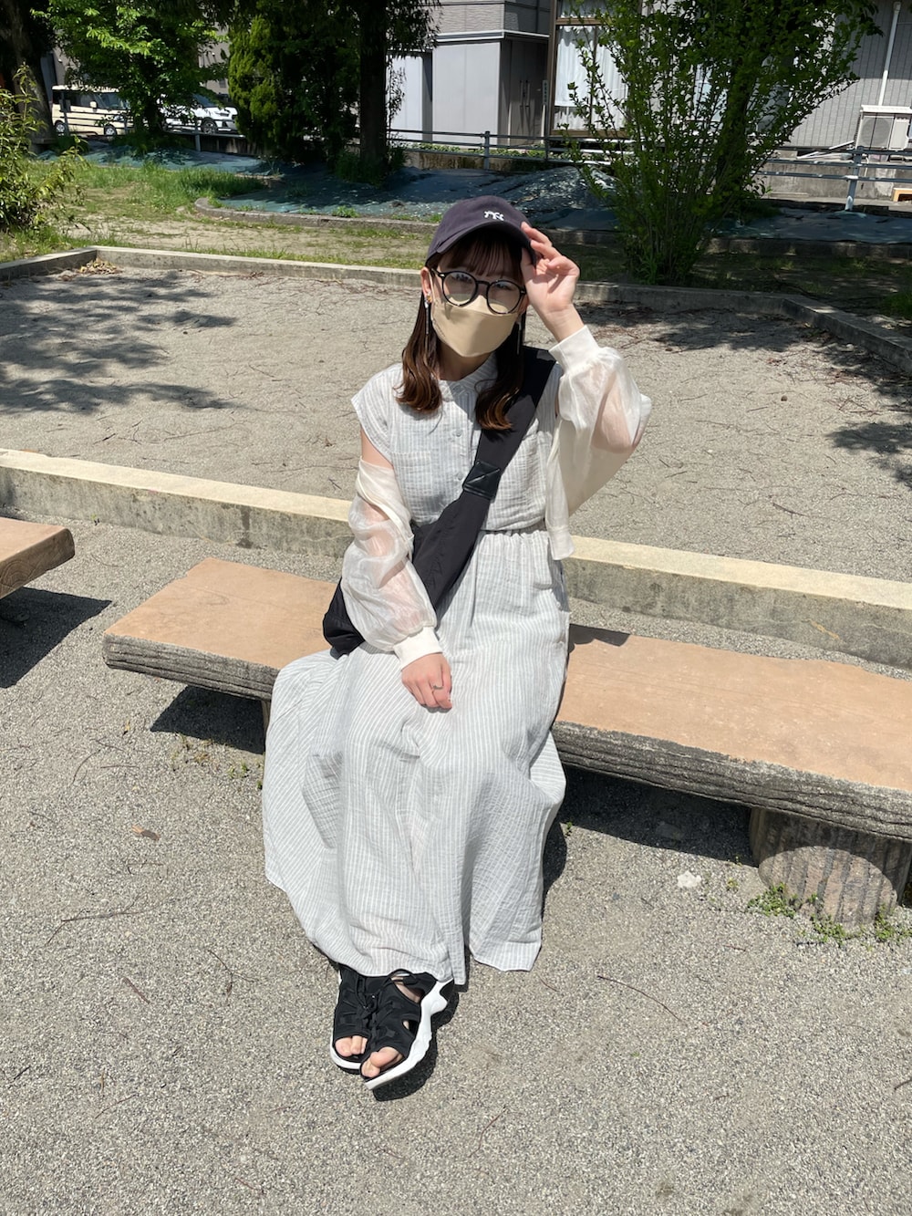 グレー系のシャツ/ブラウス、グレー系のスカート、ブラック系のショルダーバッグを着用したレディースの春コーディネートの5枚目の写真
