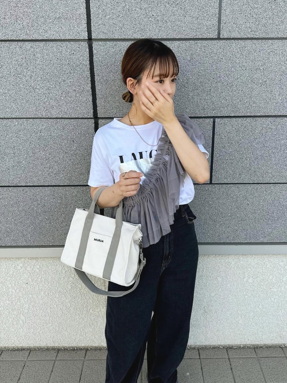 ホワイト系のトートバッグ、グレー系のその他トップス、ブラック系のデニムパンツを着用したレディースの春コーディネートの3枚目の写真