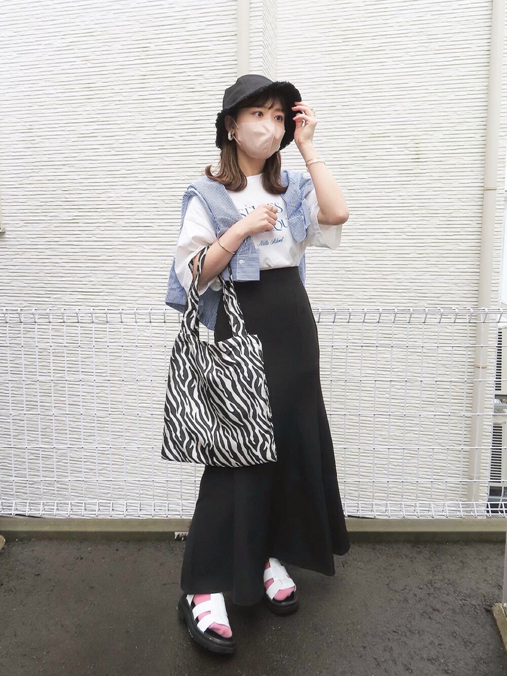 ブルー系のシャツ/ブラウス、ブラック系のスカート、ブラック系のトートバッグを着用したレディースの夏コーディネートの2枚目の写真