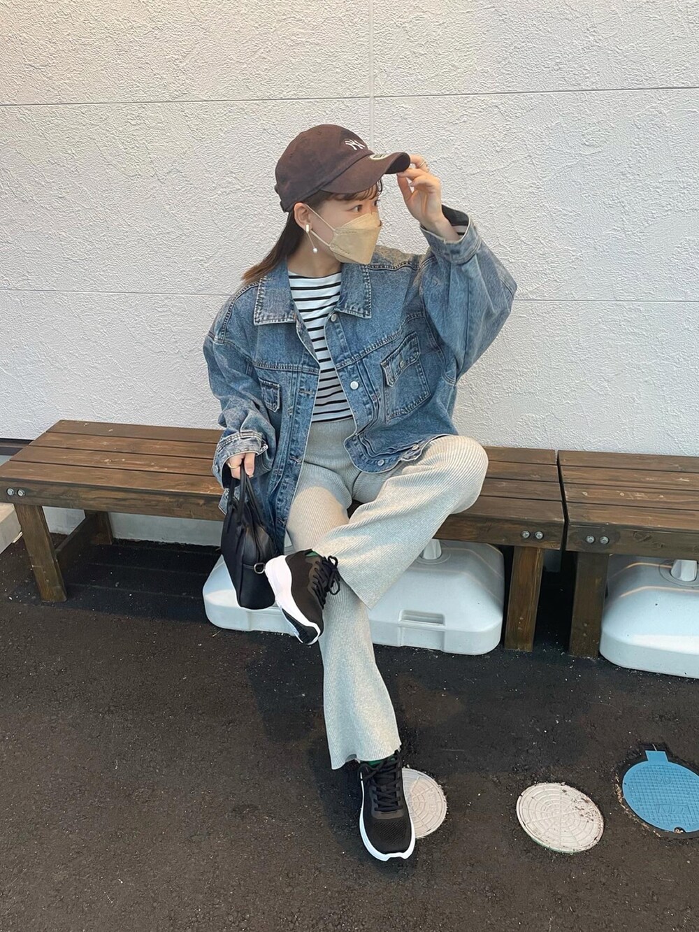 ブルー系のデニムジャケット、グレー系のその他パンツ、ブラック系のスニーカーを着用したレディースの春コーディネートの2枚目の写真