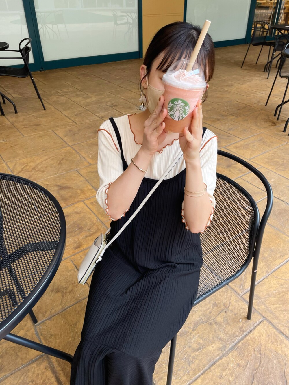 ベージュ系のTシャツ/カットソー、ブラック系のワンピース、ブラック系のサンダルを着用したレディースの夏コーディネートの4枚目の写真