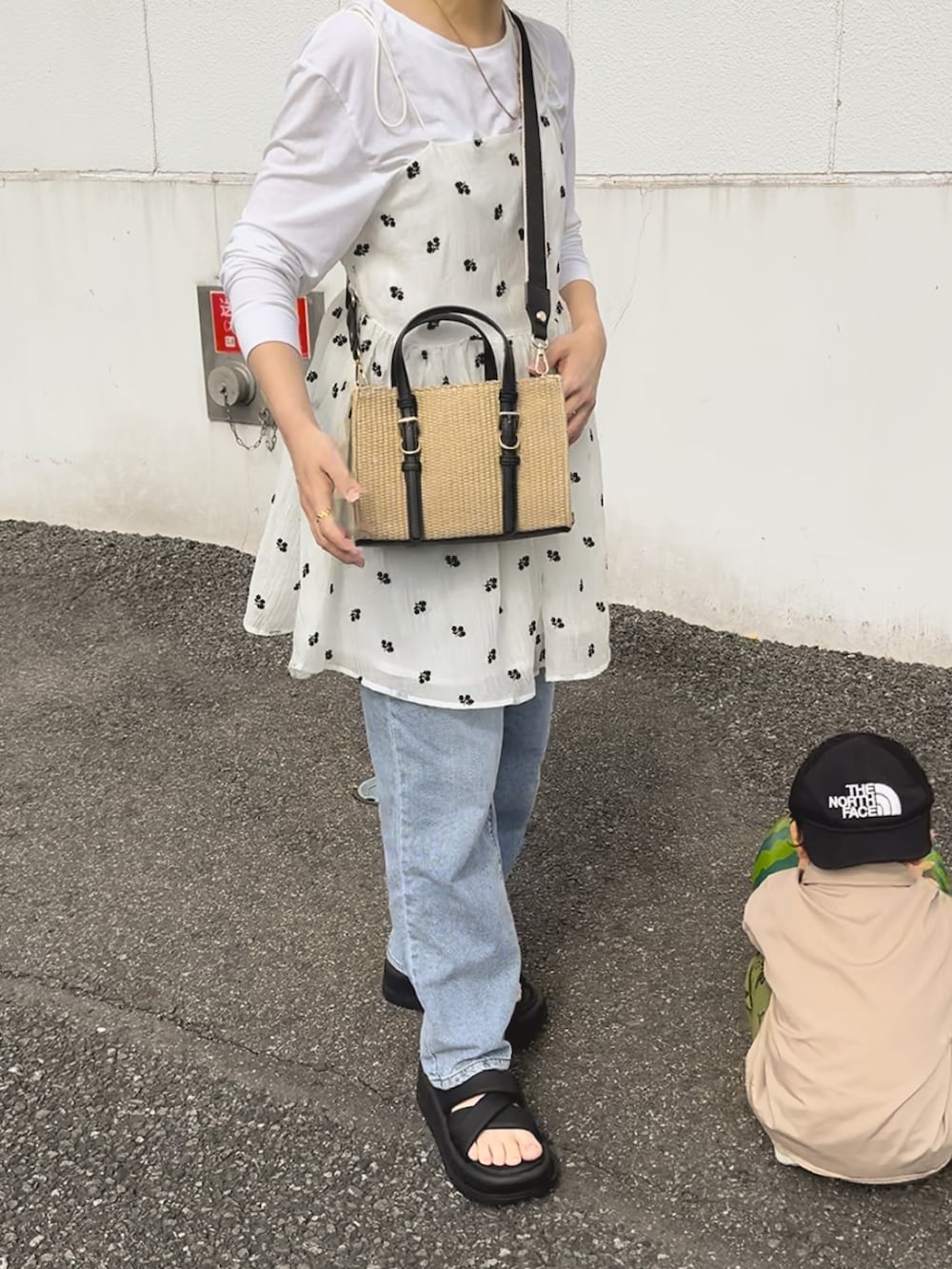 ホワイト系のチュニック、ブルー系のデニムパンツ、ブラック系のサンダルを着用したレディースの夏コーディネートの2枚目の写真