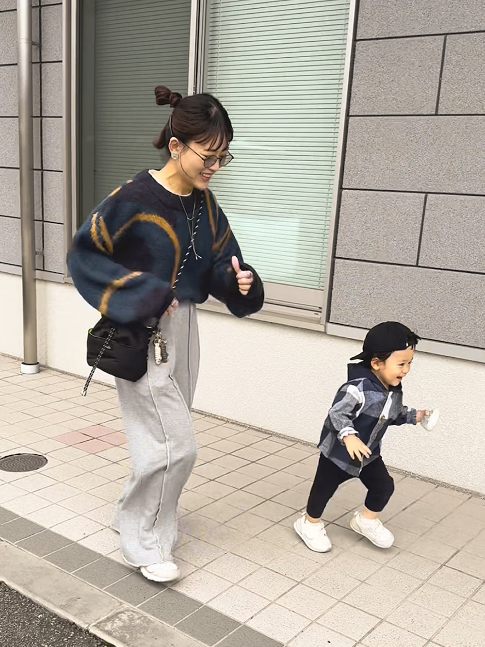 グレー系のスウェットパンツ、ブルー系のニット/セーター、ホワイト系のスニーカーを着用したレディースの冬コーディネートの3枚目の写真